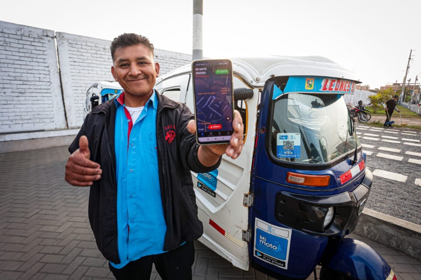 Conductor muestra la app Mi Moto Segura junto a su unidad con QR